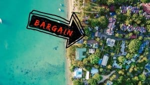 An aerial view down at homes along the beach with an arrow pointing to bargain properties.