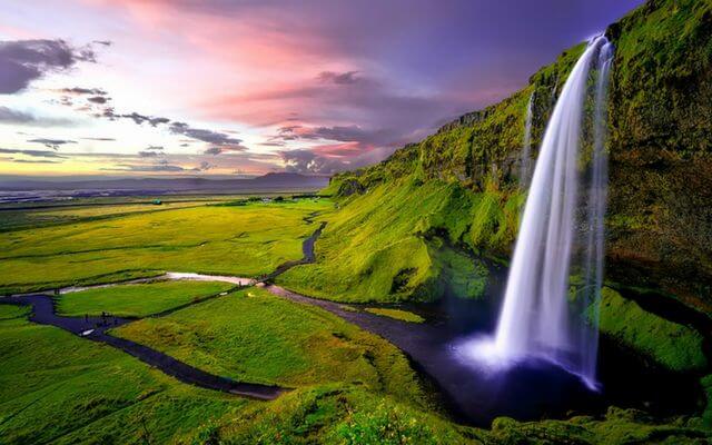 A waterfall in Iceland flows into a river