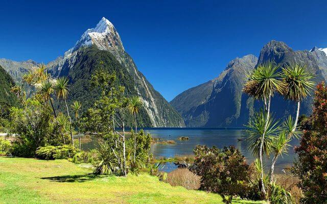 A lake in New Zealand with snow capped mountains in the distance