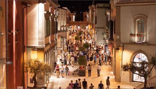 an italy street at night with people shopping