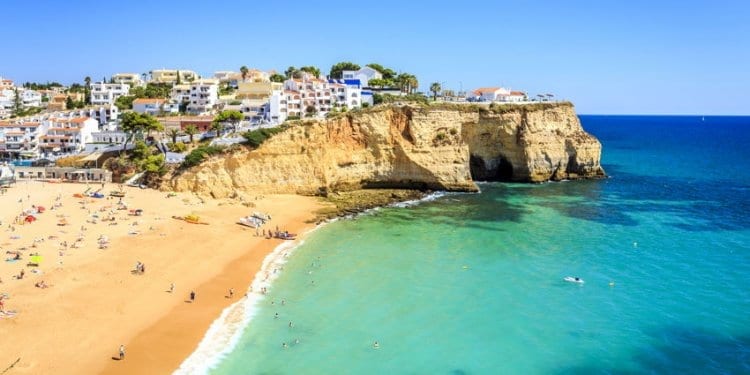 View of the Carvoeiro beach on the Algarve, Portugal. Yellow sand and clear, blue sea