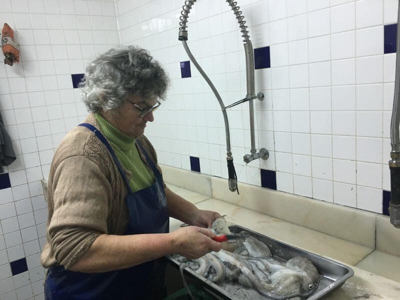 lady preparing octopus in algarve portugal