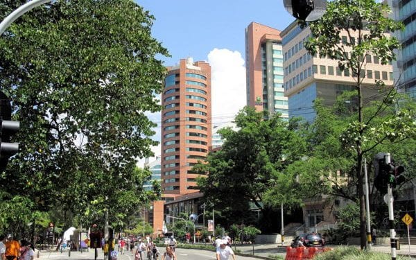 view from the street with people and building in the bakcground of el poblado in medellin, colombia
