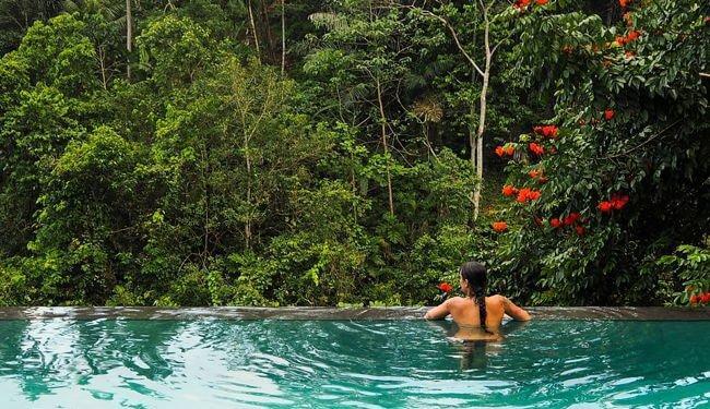 Woman in an outside pool in the Bali jungle. Best places to honeymoon