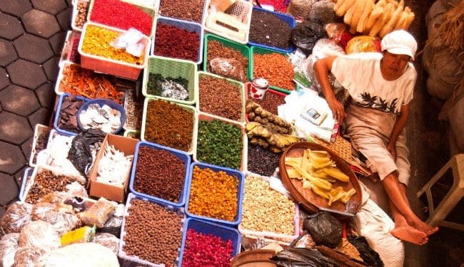 A market stall owner rests in front of his spices in Beringharjo market, Indonesia