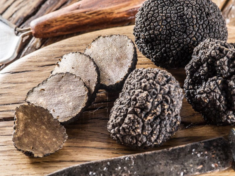 Black truffles on a wooden chopping board