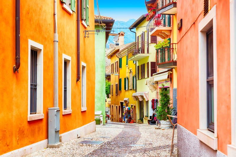 Quiet street with colorful houses in Italy. Find out how real estate overseas can protect your assets