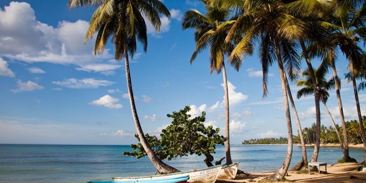 An empty beach with colorful boats on the sand in Las Terrenas, Dominican Republic.