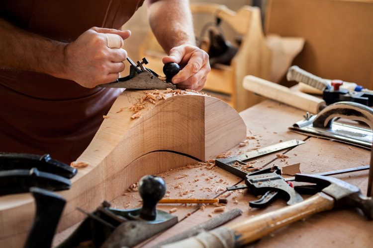 Carpenter works with a planer in a workshop