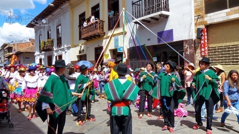 People wearing beautiful dresses and dancing during a parade Paseo del Nino Viajero. 