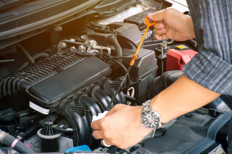 man checking oil levels of his car