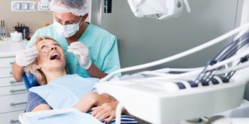 Male dentist treating female patient