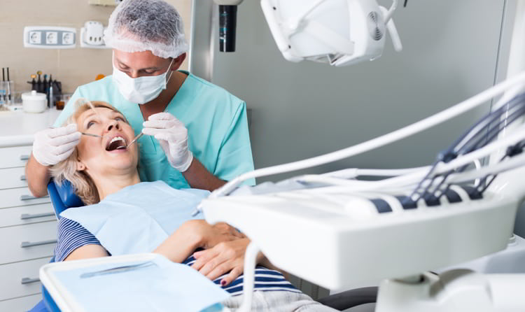Male dentist treating female patient