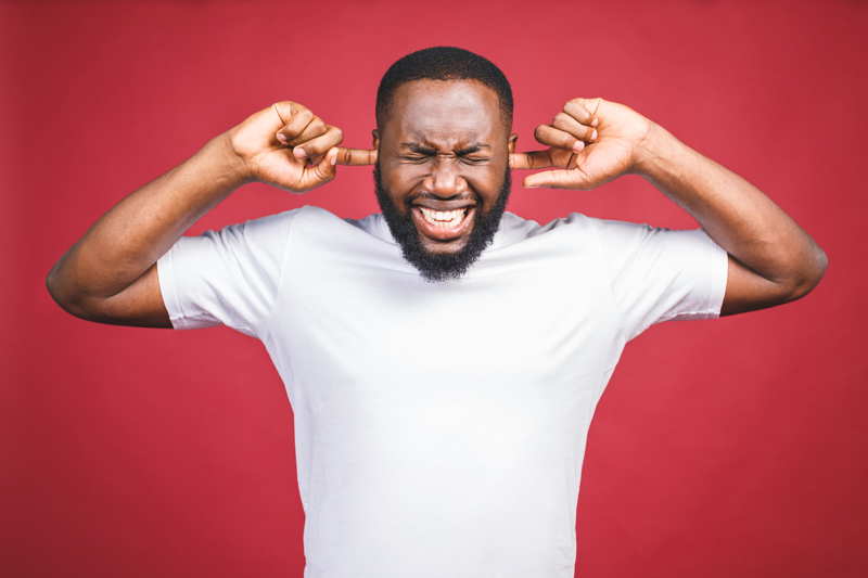 too noisy man with fingers in his ears