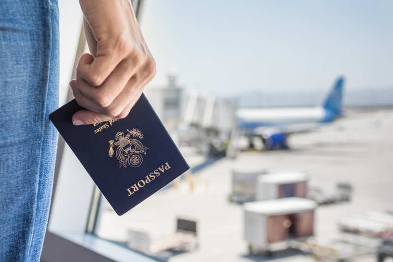 a woman holds her passport at the airport