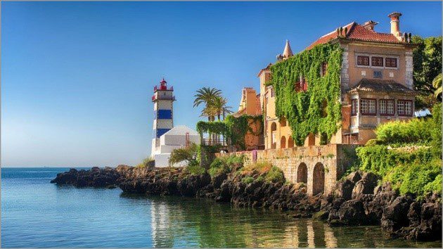 A lighthouse and a big orange house near the sea