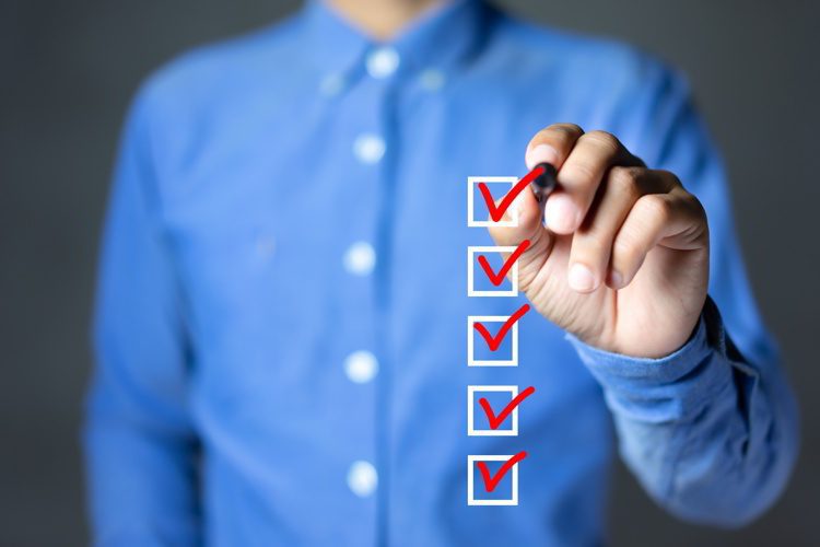 Businessman checking mark on the check boxes with marker red