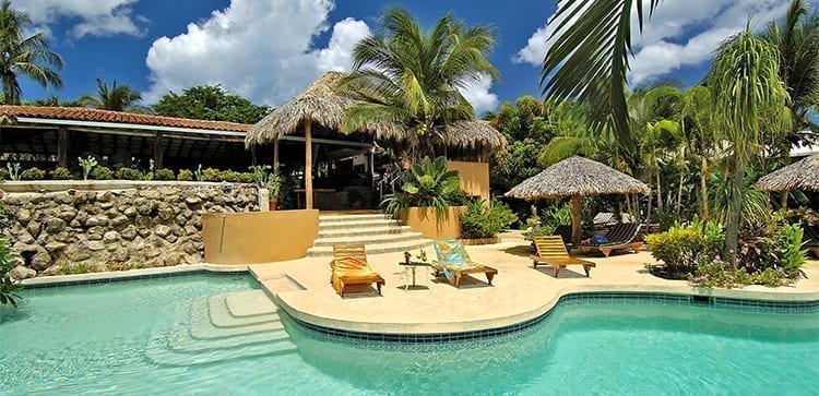 beautiful pool and lounge chairs and palm trees at a tropical resort