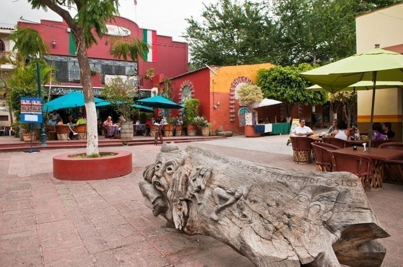 Wooden sculpture and cafes on the main plaza in Ajijic, Mexico