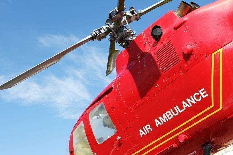 Red helicopter of air ambulance isolated on blue sky background