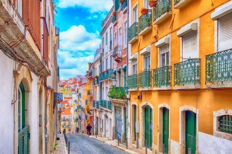 Lisbon, Portugal street perspective view with colorful traditional houses.