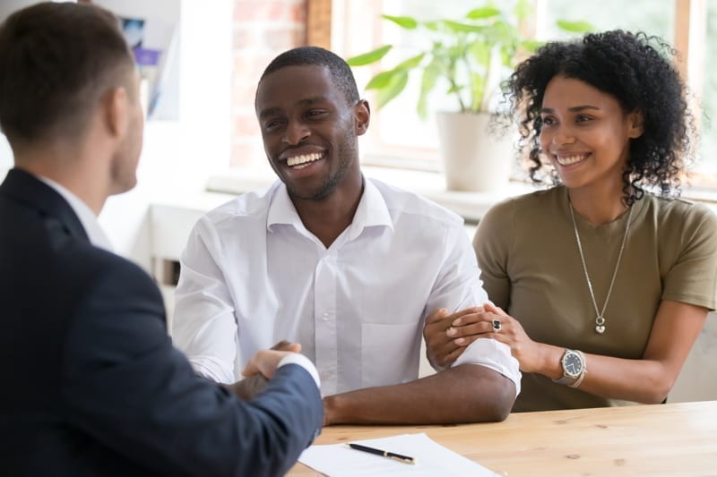Couple handshaking realtor worker at meeting. 