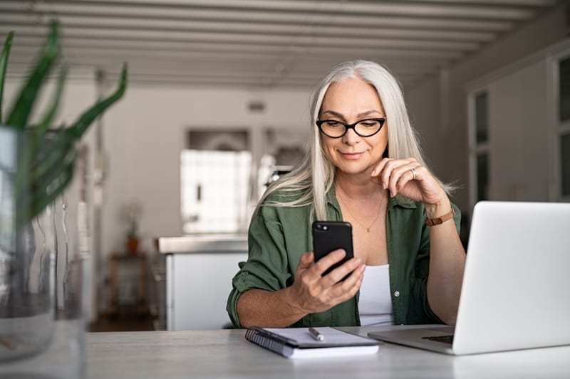 Happy senior woman using mobile phone. 