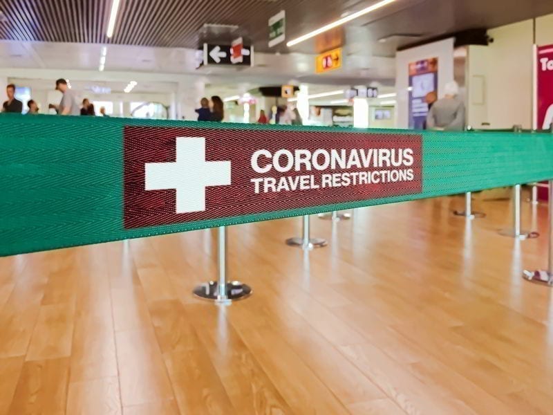 Green ribbon barrier inside an airport with the warning of travel restrictions due to the spread of the dangerous Coronavirus. 