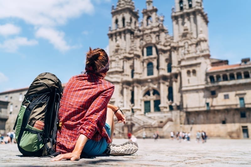 Woman siting on the Obradeiro square (plaza) in Santiago de Compostela. 