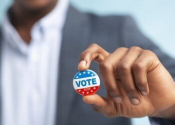Man holding vote button.