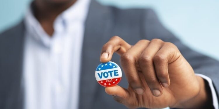 Man holding vote button.