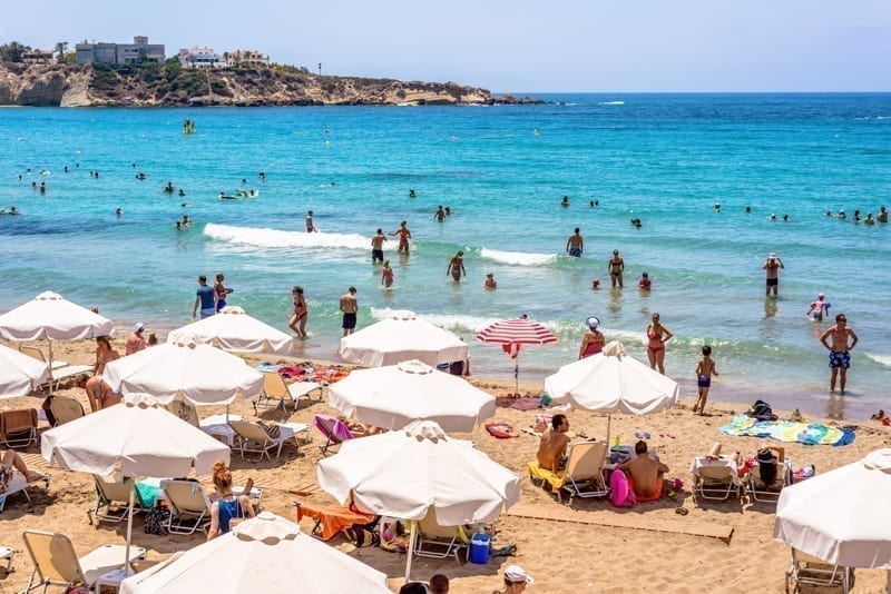 Tourists and locals enjoying a nice summer day at the Coral Bay Beach, Cyprus. 