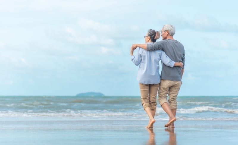Happy senior couple on the beach enjoying their overseas retirement