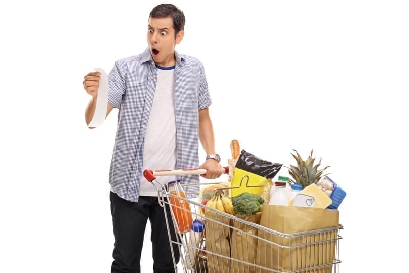 Shocked man looking at a store receipt 