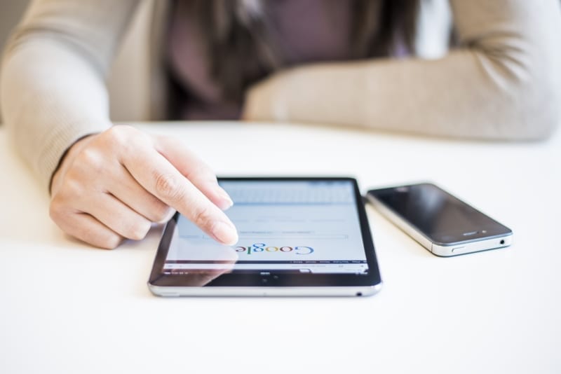 Woman's hands Googling on electronic device