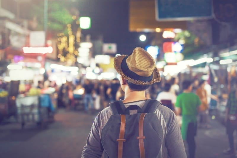 Backpacker in Khaosan Road night market in evening in Bangkok, Thailand