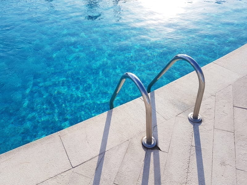 Ladder of the swimming pool cast a shadow. 