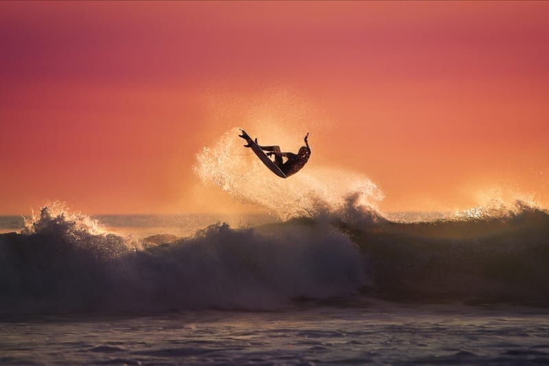 A surfer getting air from a wave