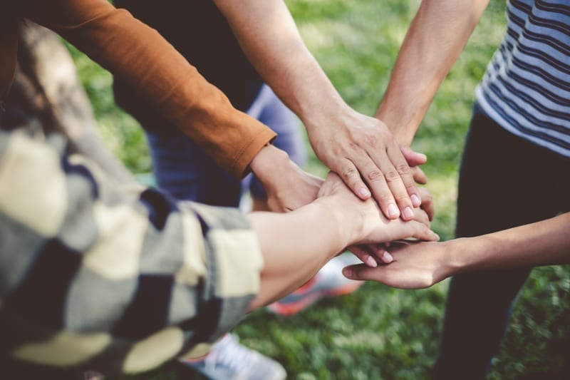 Stacking hands of young teen student, volunteering concept.