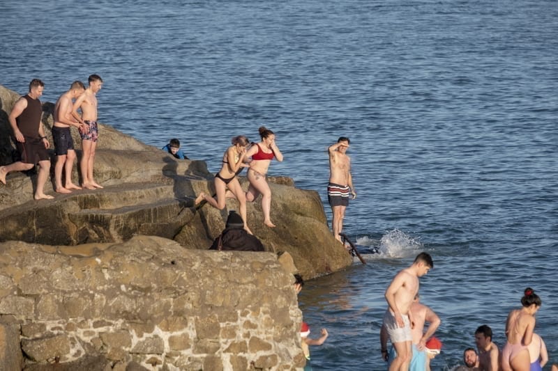 People jumping into the sea at Forty Foot during Christmas traditional swim. Dublin, Ireland. 