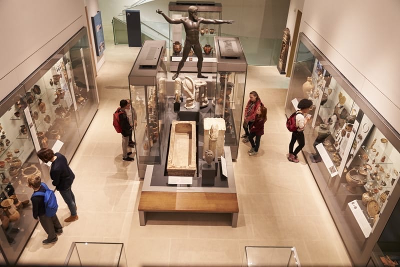 Overhead view of busy museum interior with visitors. 