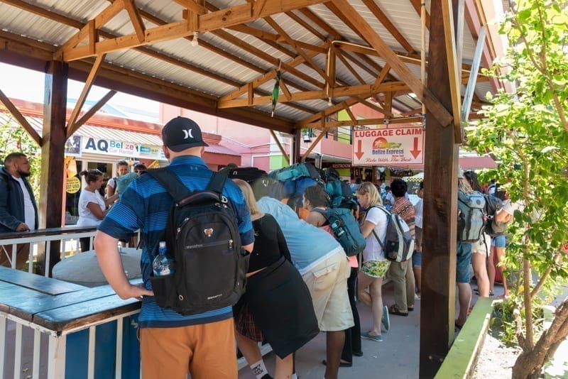 Group of tourists waiting for their luggage at the Belize Marine Terminal 