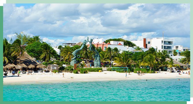 A beautiful white sand beach with green palm trees in Mexico