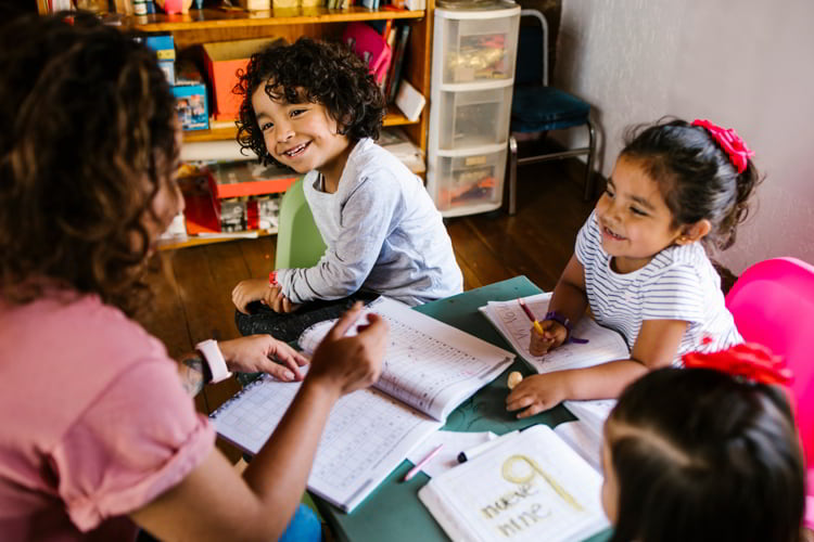 Three small children happily doing school work