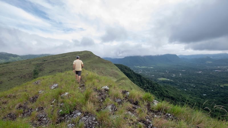 Male hiker walking on top of India Dormida mountain at El Valle de Anton, Panama