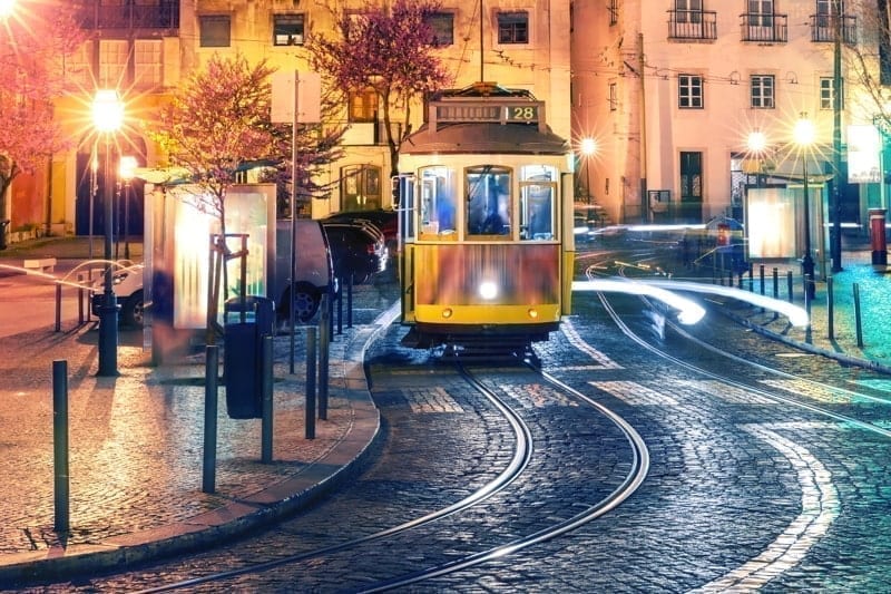 Yellow 28 tram in Alfama at night, Lisbon, Portugal.