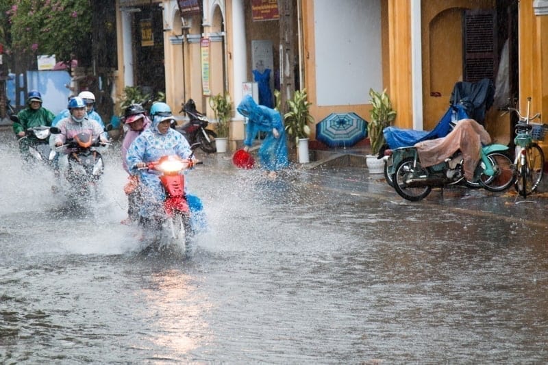 Hoi An, Vietnam. Heavy rain and storms in the wet season soak people and scooter riders