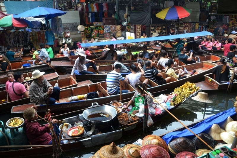 People on boats on a floating market in Thailand