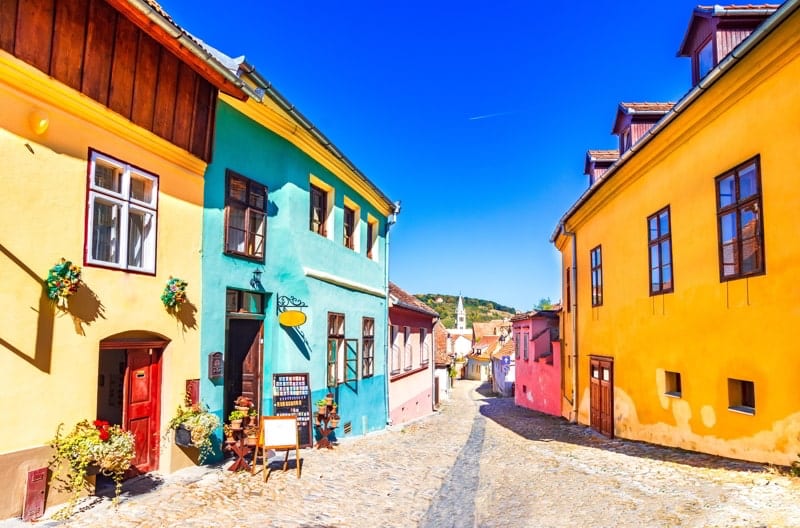 Famous stone paved old streets with colorful houses in Sighisoara, Romania.