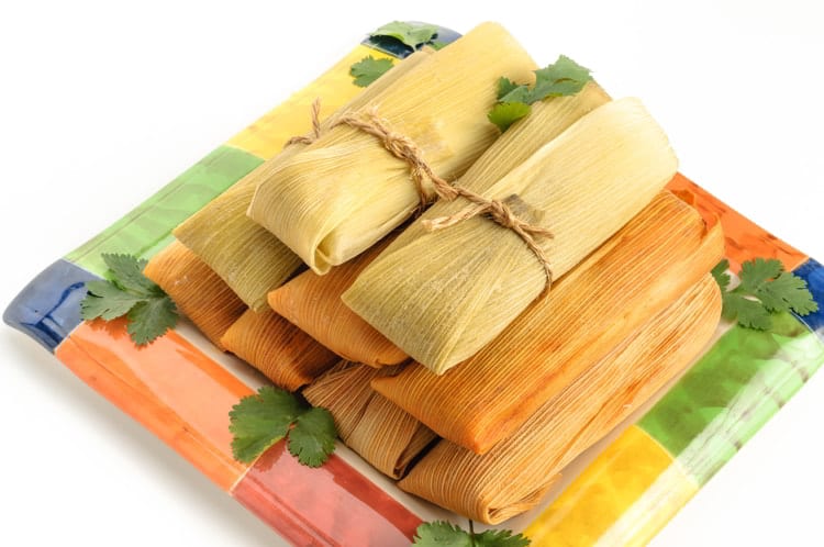 Tamales, Mexican dish made with corn dough, chicken and chili, wrapped with a corn leaf